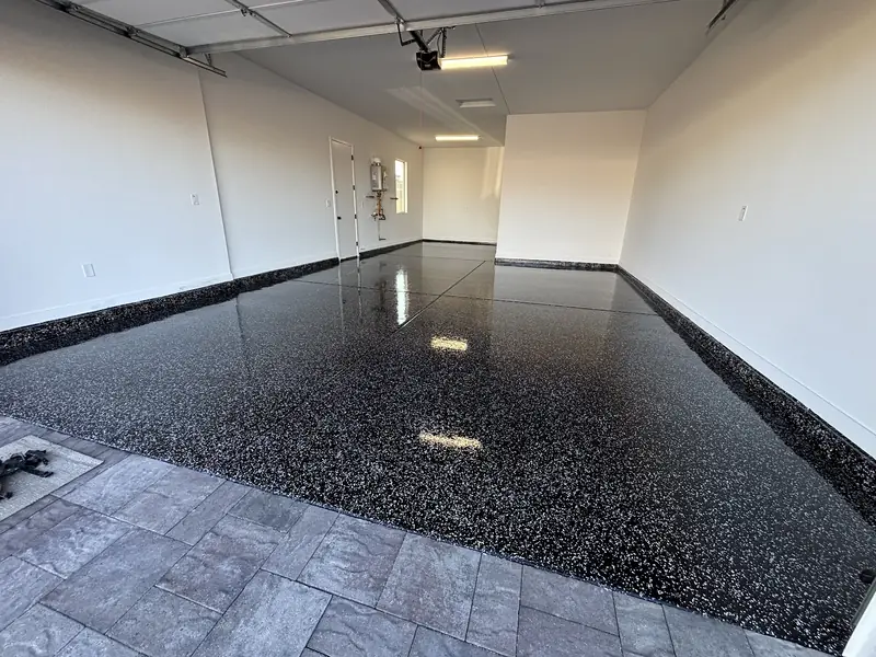 Glossy black flake epoxy floor in a two-car garage