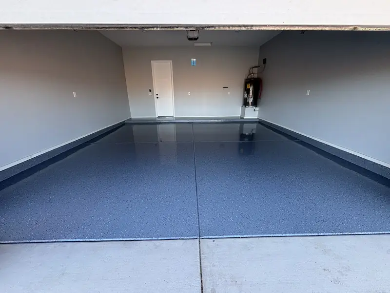 Blue-grey flake epoxy floor in a garage with the door open