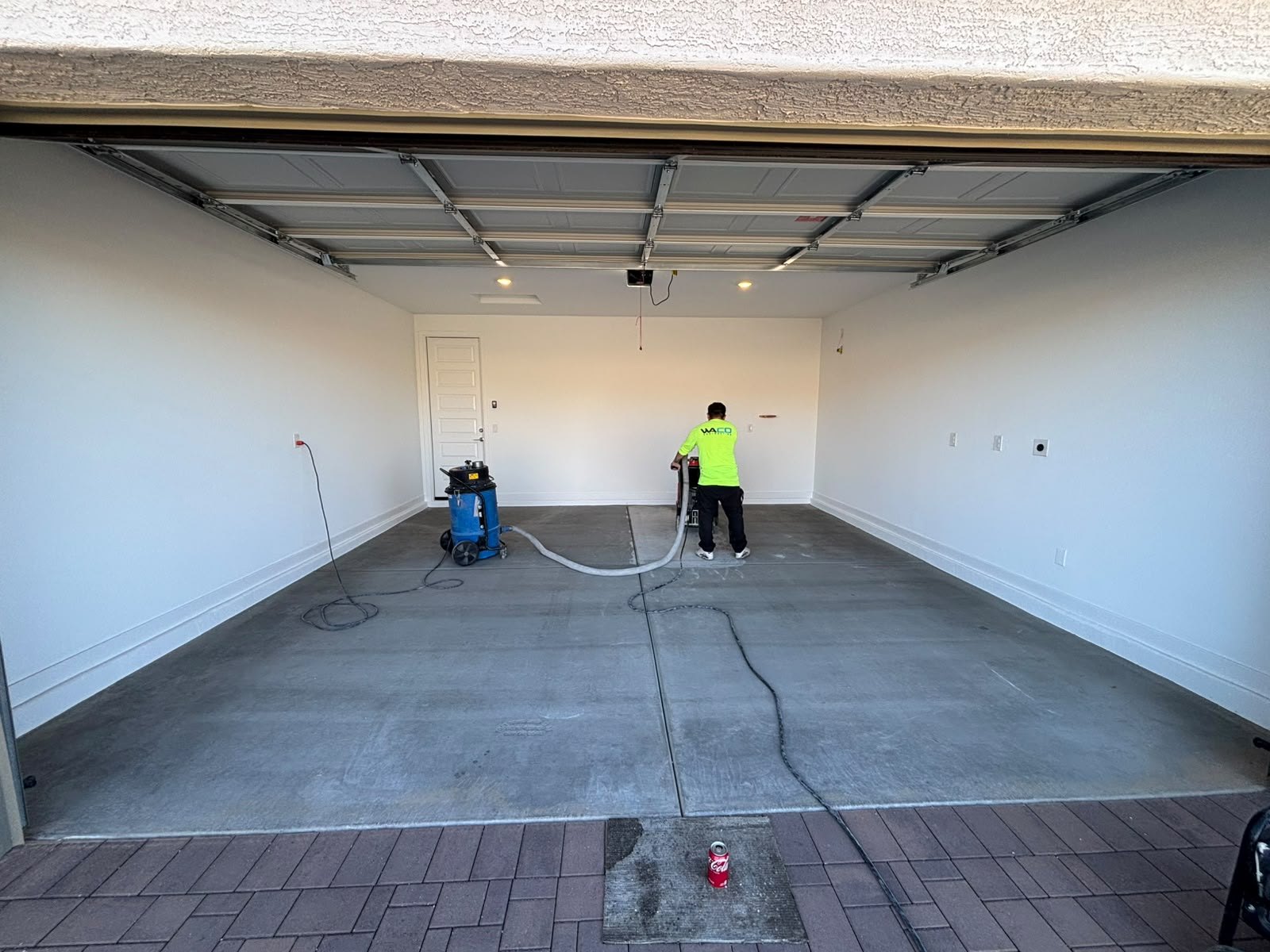 AMR crew vacuuming a bare garage slab before coating